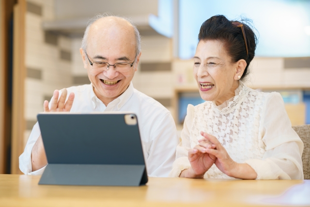 高齢夫婦がタブレットで会話する